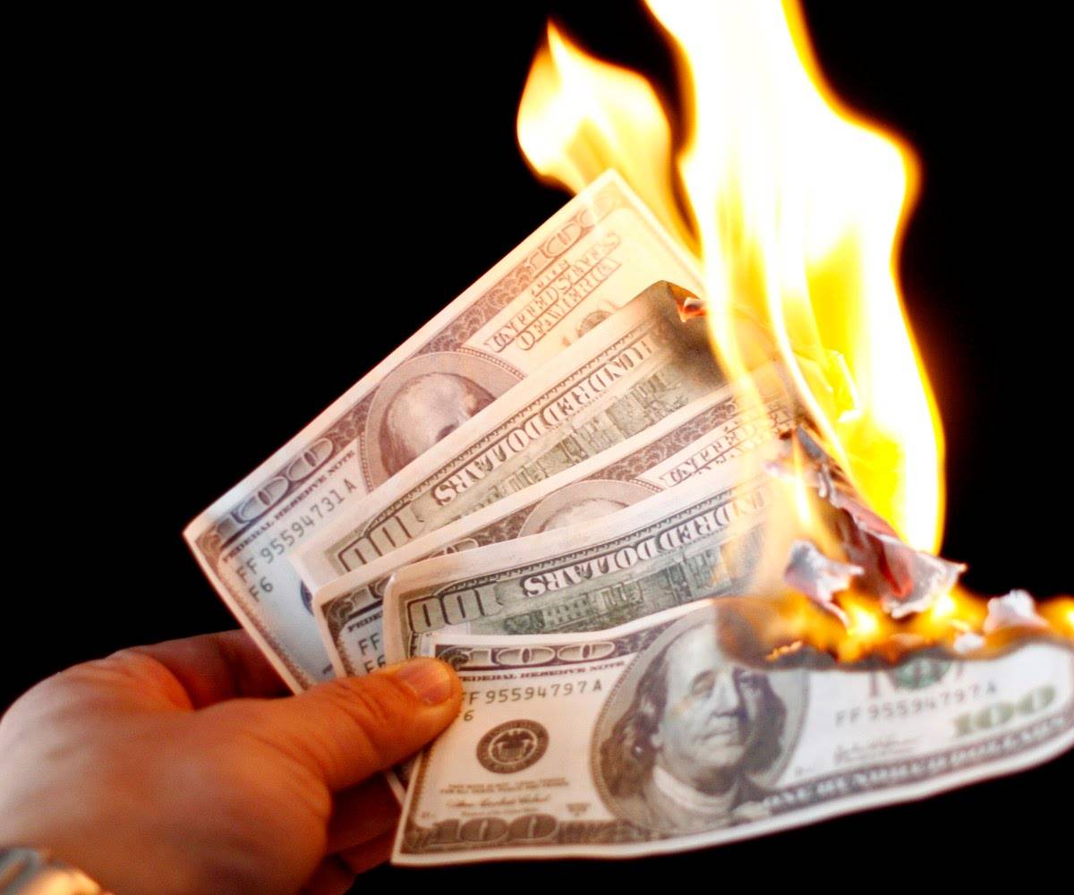 Сжигание денег. Сжигает деньги. Деньги сгорают. Доллар в огне.